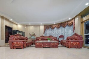 A spacious living room with a fireplace, a large sofa set, and a decorative curtain. - Huaihua Hongxing Hotel (Transit Library South High-speed Railway Station) (Huaihua)