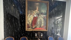A room with a black and white checkered floor, a large portrait on the wall, and two blue upholstered chairs. - Victoria Cairo Hotel (Cairo)