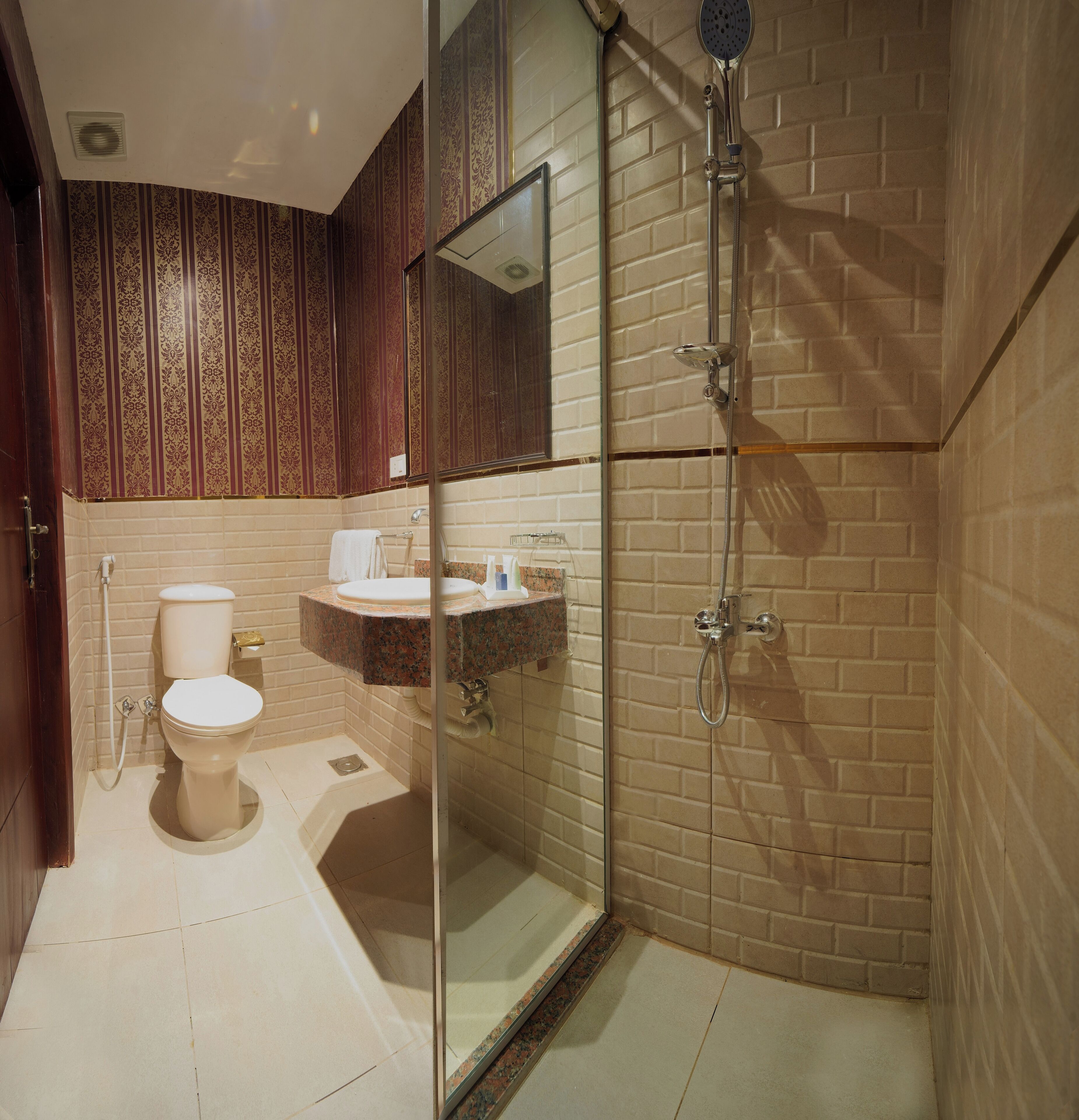 A bathroom with a toilet, sink, and shower.