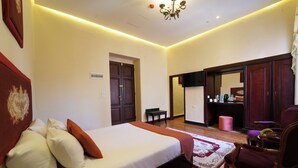 A hotel room with a large bed, a wooden floor, a desk, a chair, and a wardrobe. - Victoria Cairo Hotel (Cairo)
