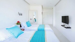 Ein Hotelzimmer mit zwei Betten, einem Fernseher und einem Telefon an der Wand.