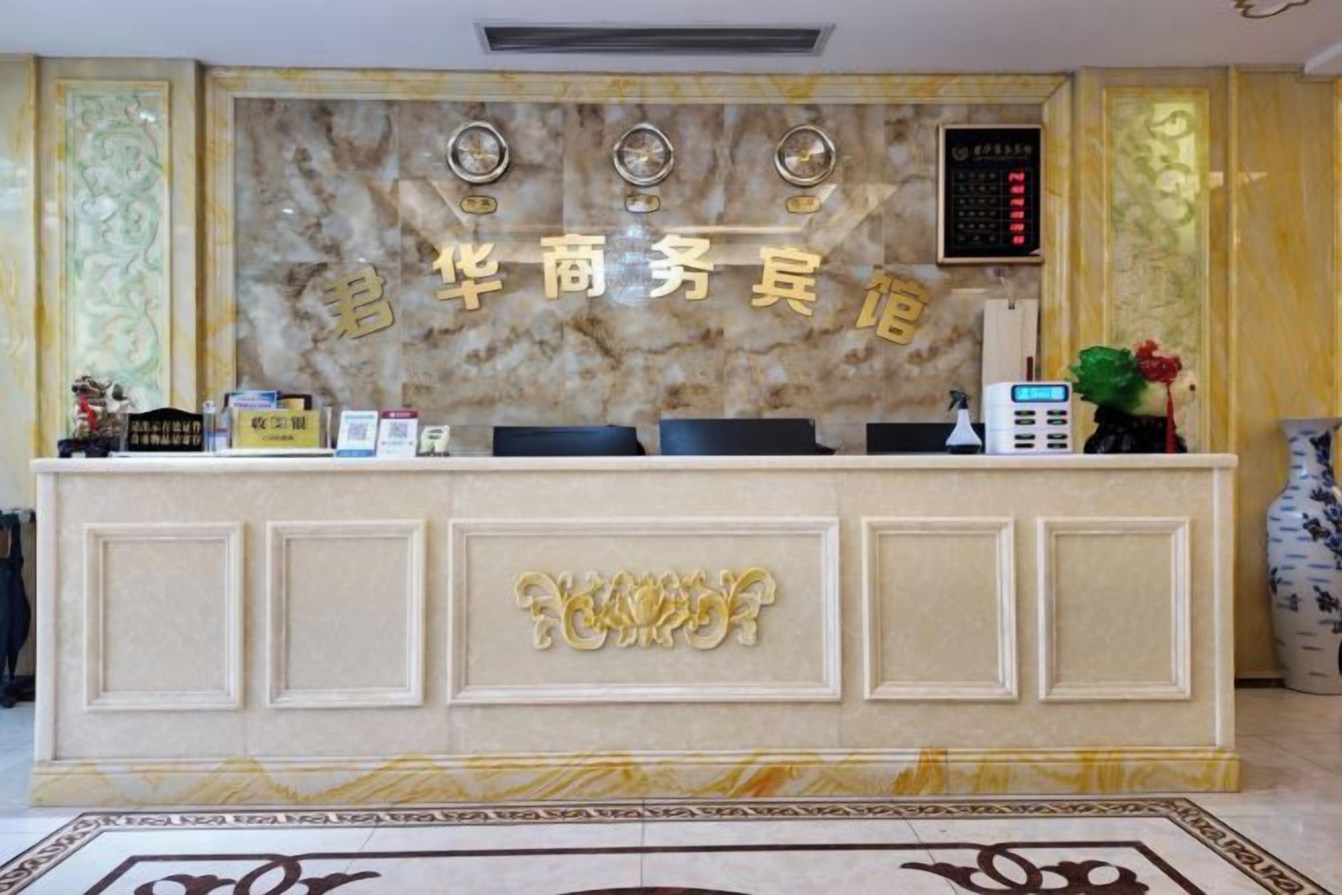 A reception desk with a marble backdrop, a digital clock, and a telephone.
