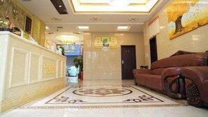 A hotel lobby with a reception desk, a chandelier, a large painting, and a sofa. - Xuan'en Junhua Hotel (Xuan'en)