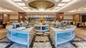 Eine Hotelhalle mit einer zentralen Rezeption, einem großen Chandelier und einem Marmorboden.