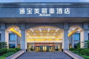 A hotel entrance with a modern design, featuring a large arched entrance and a well-lit facade. - Merlinhod Hotel (Yuncheng Airport, North Railway Station) (Yuncheng)
