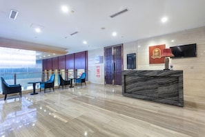 A hotel lobby with a reception desk, seating area, and a large window. - Merlinhod Hotel (Yuncheng Airport, North Railway Station) (Yuncheng)