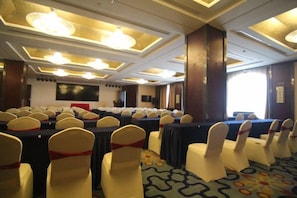 A conference room with rows of tables and chairs, a large screen, and a patterned carpet. - Merlinhod Hotel (Yuncheng Airport, North Railway Station) (Yuncheng)