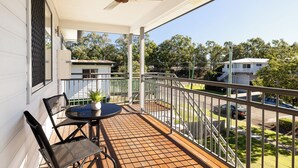 A balcony with a table and chairs, a ceiling fan, and a view of neighboring houses. - Private Rocklea 2BR | Parking | Kitchen | 119D2 (Rocklea)