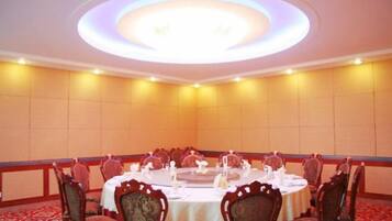 A conference room with a round table, chairs, and a ceiling light fixture.