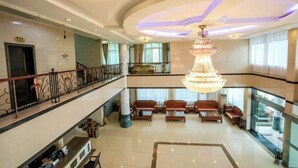 A spacious lobby with a grand chandelier, multiple seating areas, and a staircase leading to an upper level. - Jin Xiu Hotel (Yushan)