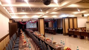 A conference room with a long table, chairs, and a projector screen. - Jin Xiu Hotel (Yushan)
