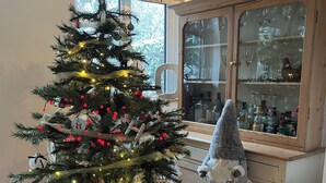A Christmas tree with ornaments and lights, a star on top, and a bag labeled "North Pole" at its base.