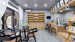 Un restaurante con mostrador, sillas, mesas y estanterías con productos.