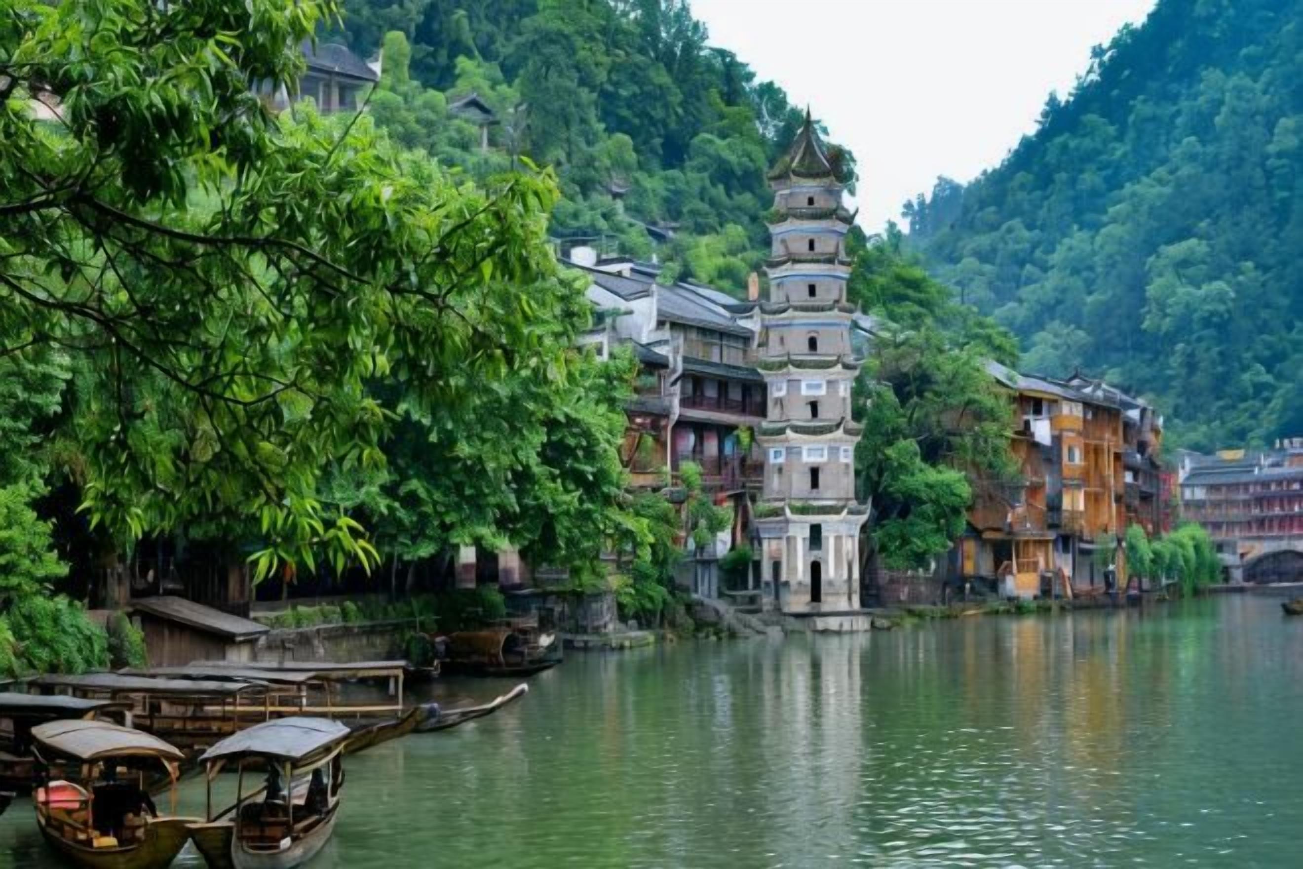 A traditional building with a multi-tiered pagoda-style roof, situated beside a river with boats.