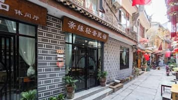 A traditional Chinese restaurant with a brick facade, large windows, and outdoor seating.