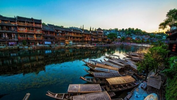 Vista junto al río con edificios tradicionales y barcas de madera amarradas.