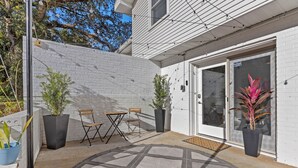 A patio with a black and white patterned rug, a wooden table and chairs, and potted plants. - Private Garden Retreat - King Bed - mins TMH + Downtown + FSU! (Tallahassee)
