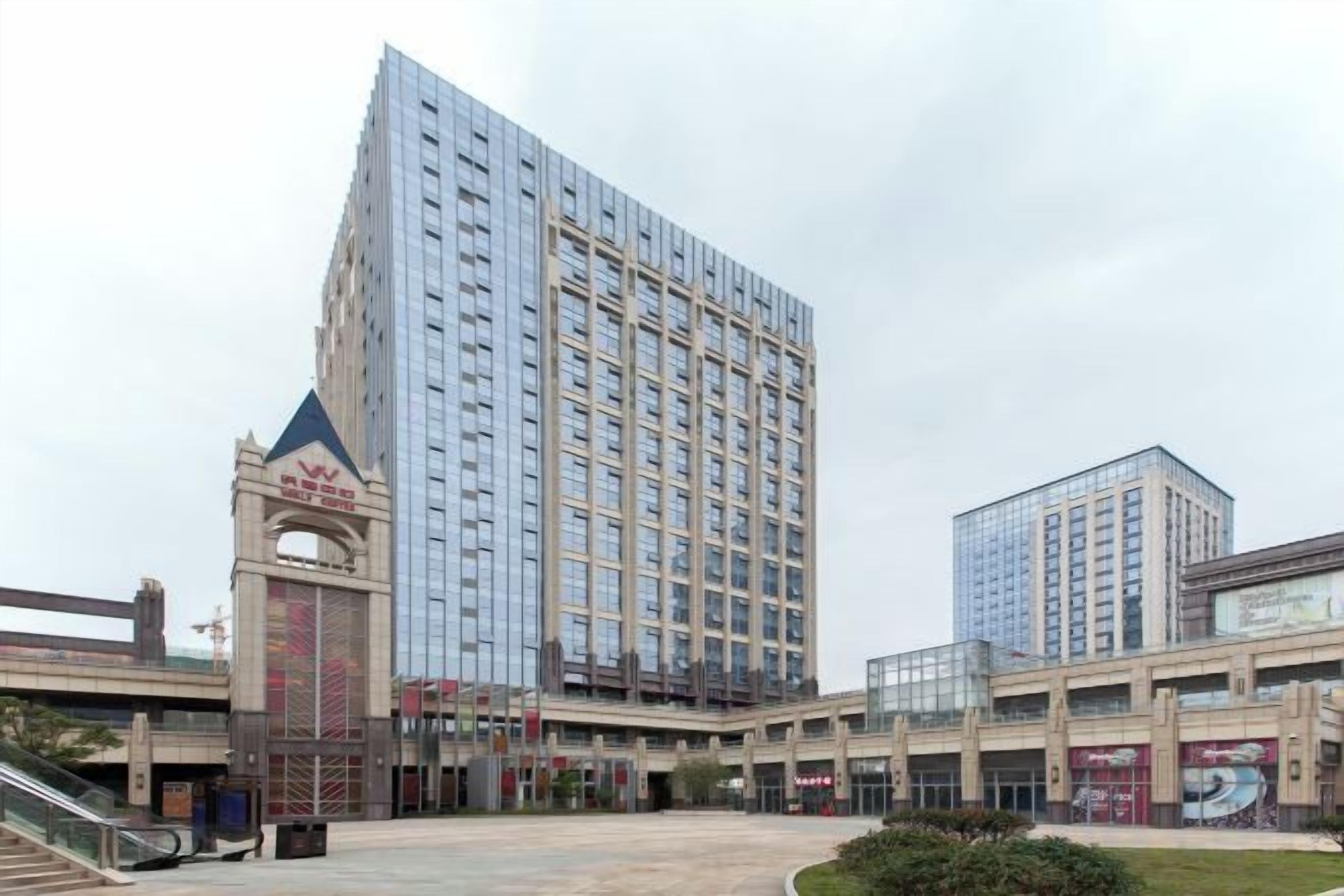 A modern hotel with a central atrium, multiple floors, and a prominent entrance.