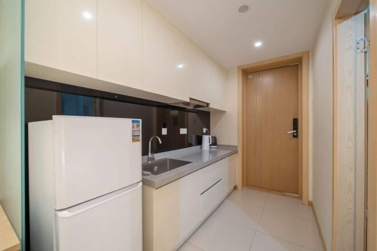 A compact kitchen with a refrigerator, sink, and countertop.