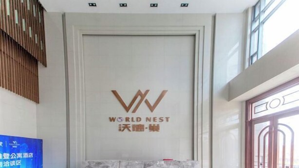 A reception area with a marble counter, a large logo for "WORLD NEST," and a modern interior design with wooden slats and large windows. - Wuhan Boya Ward Hotel (Optics Valley Convention and Exhibition Center Joy City Branch) (Wuhan)