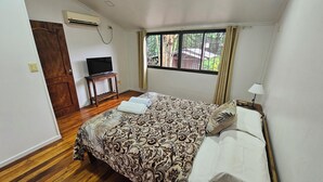A bedroom with a bed, a TV on a small table, and a window with curtains. - Wicz Apart (Puerto Iguazú)
