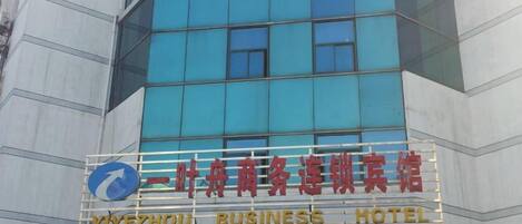 A building with a sign for Yiyezhou Business Hotel.