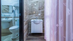 Un baño con inodoro, lavamanos y armario.