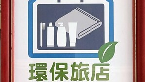 Un cartel con una maleta, cepillo de dientes y artículos de aseo, que indica un servicio de viajes o hotel.
