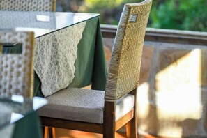 A chair with a woven backrest and a cushion, placed at a table with a green tablecloth. - Chingjing Top Cloud Resort (Nantou)