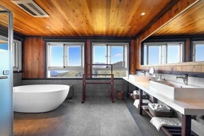 A modern bathroom with a freestanding bathtub, a wooden ceiling, and large windows offering a view of the outdoors. - Chingjing Top Cloud Resort (Nantou)