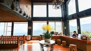 A spacious room with wooden floors, large windows, a chandelier, and a table with a plant. - Chingjing Top Cloud Resort (Nantou)