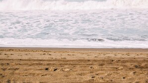 Een strand met golven die de kust naderen.