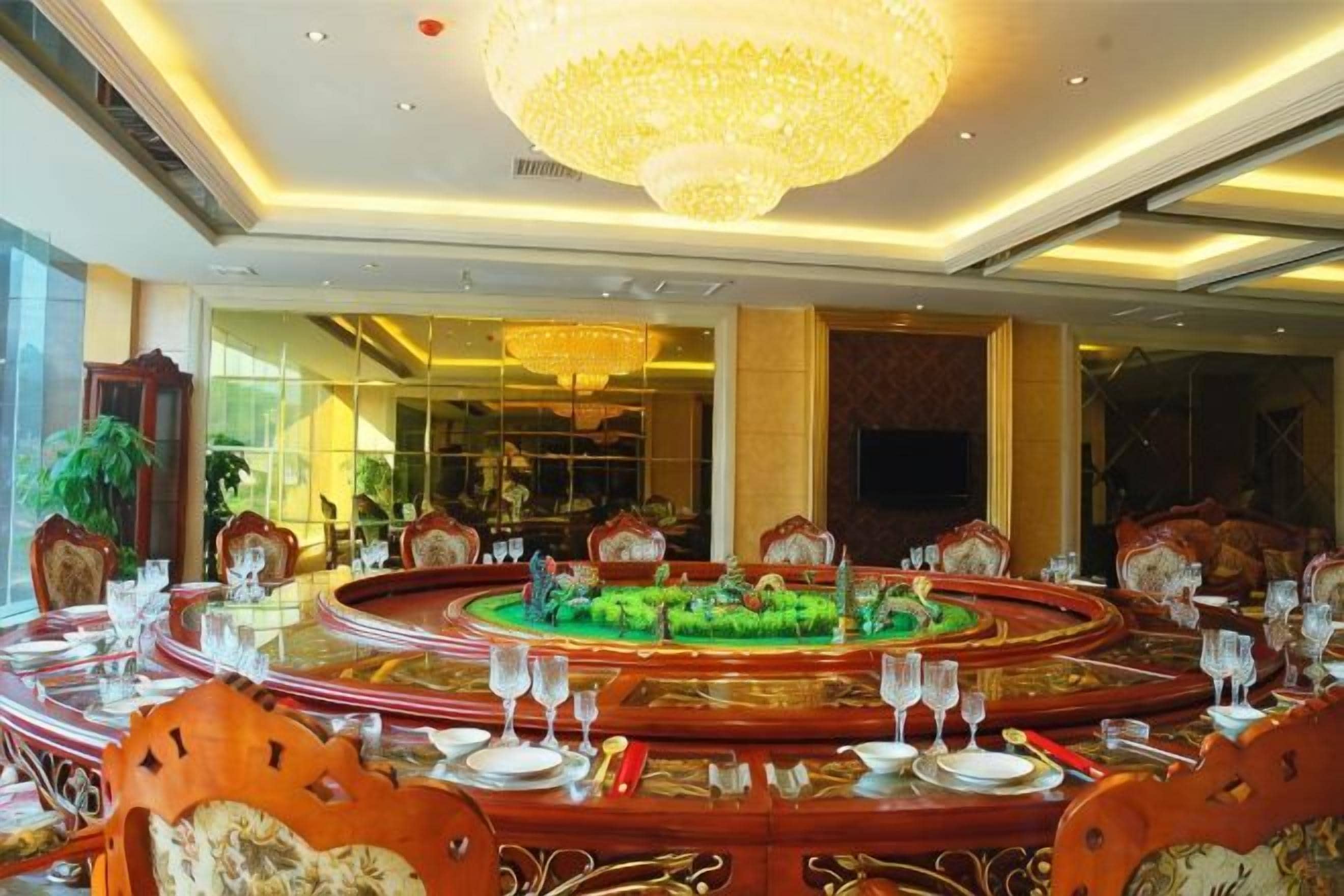A formal dining room with a round table, chairs, and a chandelier.