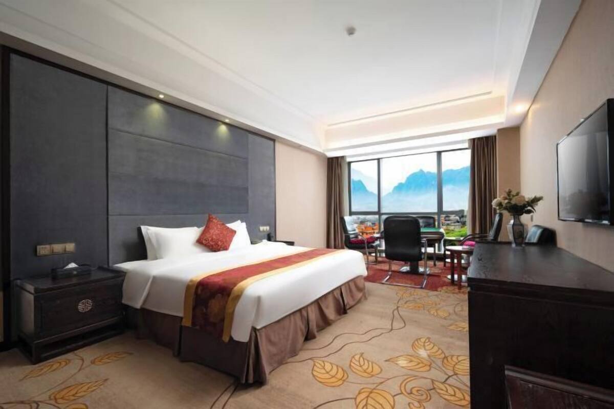 Ein Hotelzimmer mit einem großen Bett, einem Schreibtisch und einem Fernseher.