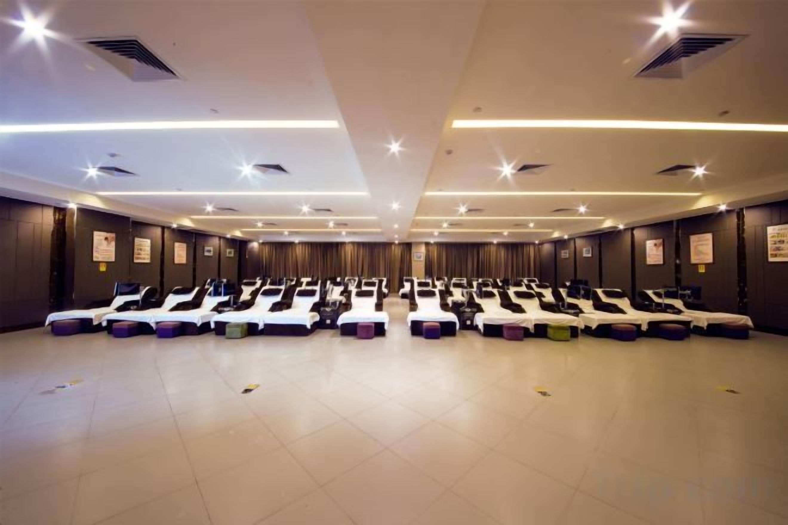 A room with multiple massage therapy beds arranged in rows.