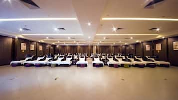 A room with multiple massage therapy beds arranged in rows.