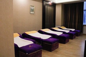 Une pièce comprenant plusieurs tables de massage disposées en rangée, une porte et une fenêtre avec des rideaux.
