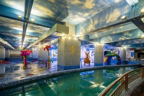 An indoor swimming pool with a ceiling that resembles clouds, surrounded by various colorful sculptures. - Zhangjiajie World Water Four Seasons International Hotel (Zhangjiajie)