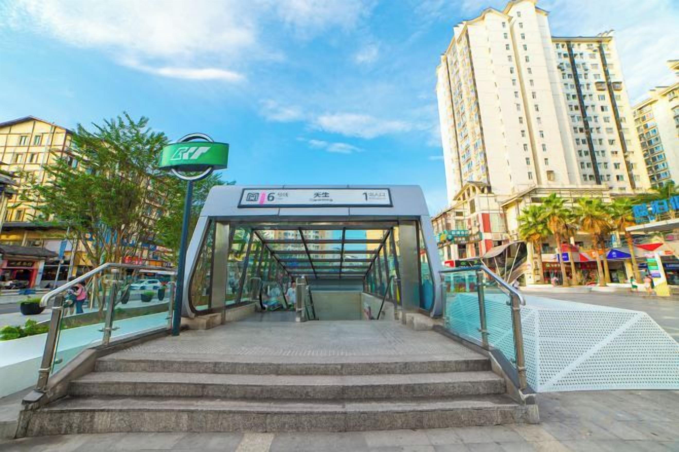 A pedestrian entrance to a building with a glass canopy and steps leading up to it.