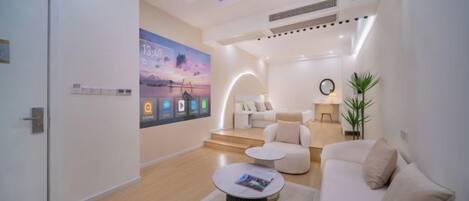 A modern living room with a sofa, coffee table, and a wall-mounted TV.