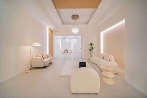 A modern hotel lobby with a sofa, a round table, and a floor lamp. - Borui Boutique Hotel (Beibei) (Chongqing)