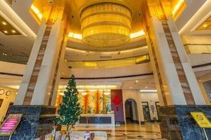 A spacious lobby with a grand chandelier, a Christmas tree, and a reception desk. - Tokang International Hotel (Tongshan)
