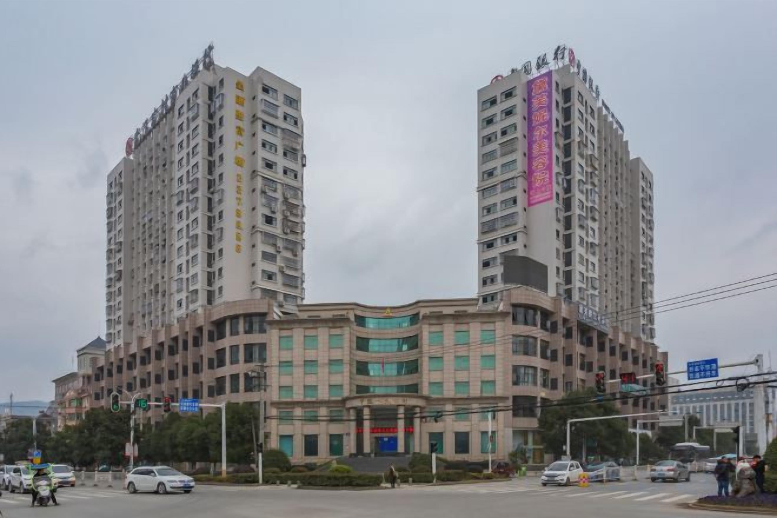 A multi-story building with a curved facade, multiple windows, and a prominent entrance.