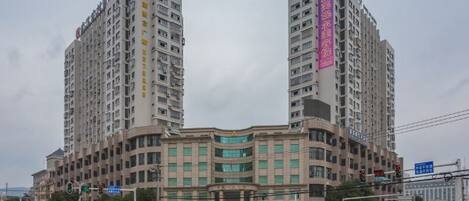A multi-story building with a curved facade, multiple windows, and a prominent entrance.