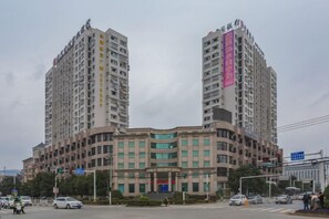 A multi-story building with a curved facade, multiple windows, and a prominent entrance.