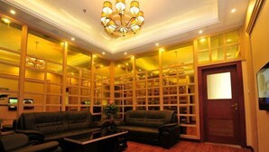 A hotel room with a large seating area, a chandelier, and a wooden bookshelf. - Tokang International Hotel (Tongshan)