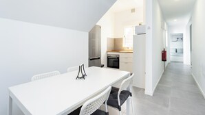 Eine moderne Küche mit weißen Schränken, einem Edelstahlkühlschrank und einer Holzarbeitsplatte.