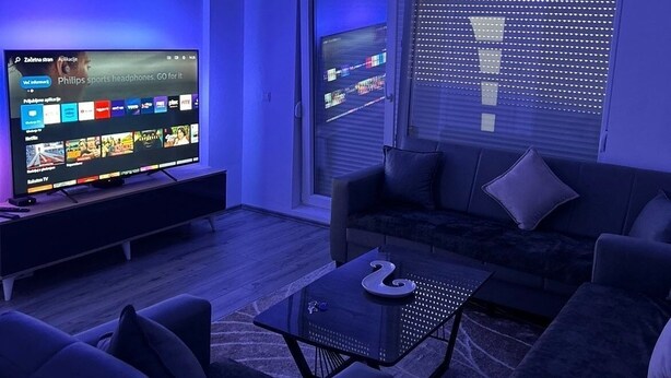 Un salon moderne avec un téléviseur à écran plat, un canapé et une table basse.