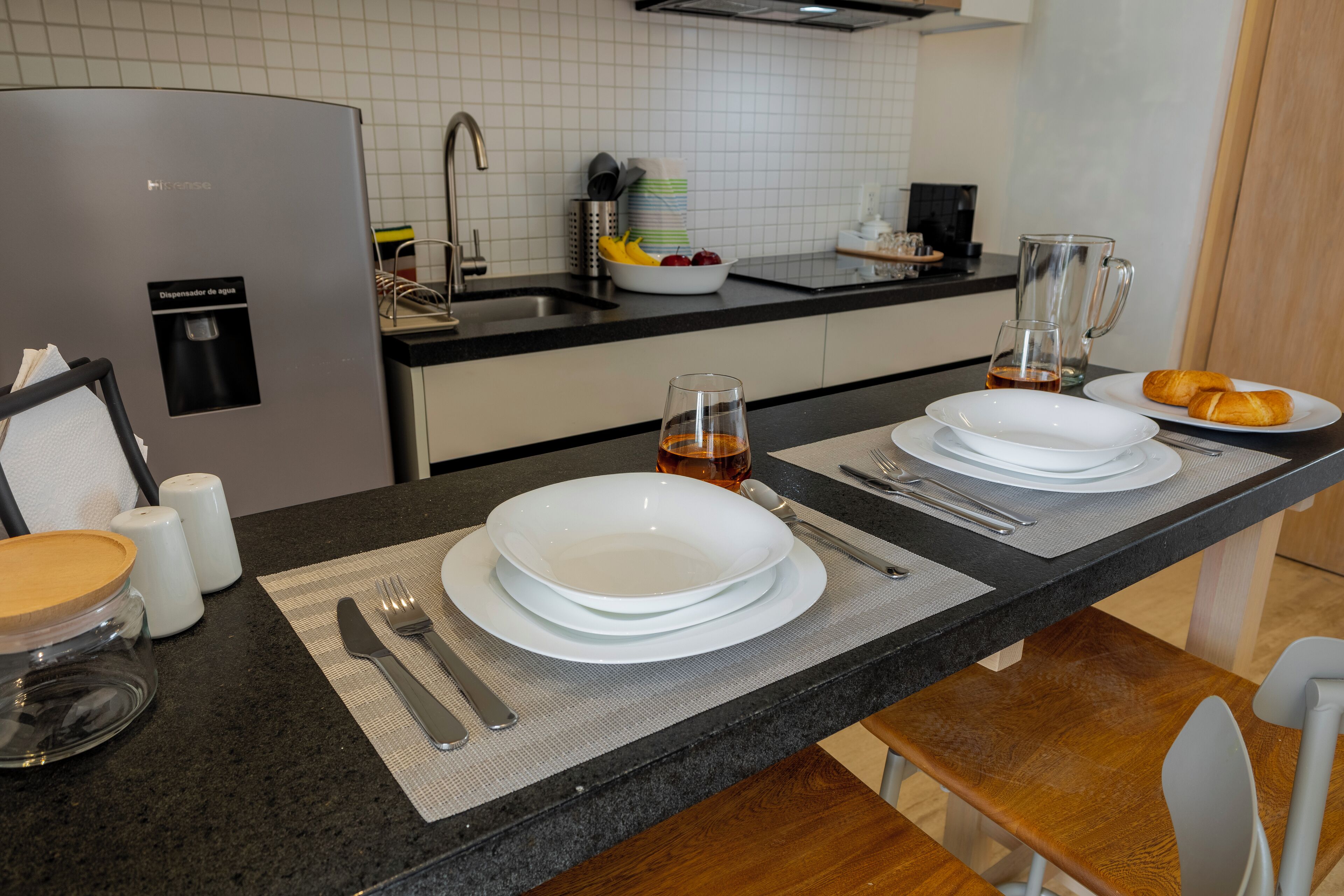 Eine moderne Küche mit integriertem Wasserspender, einer Spüle und einem Essbereich mit Tisch für zwei Personen.