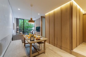Un comedor moderno con una mesa de madera, asientos tipo banca y vistas a zonas verdes.